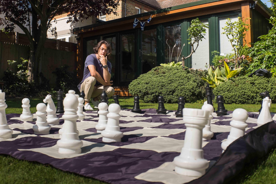 Student playing chess in school garden